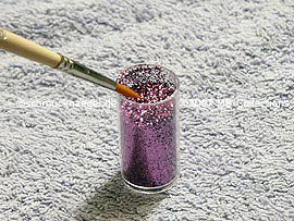 Glitter-Pulver in lila und Pinsel