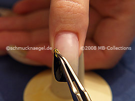 Esmalte transparente, pinzeta y un pedazo del papel de oro